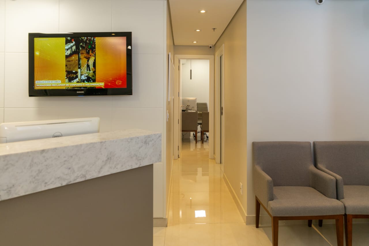 Hall da clínica, com recepção e corredor para os consultórios